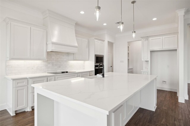 kitchen featuring white cabinets, black electric stovetop, pendant lighting, and a spacious island