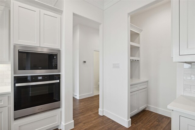 kitchen featuring oven, white cabinetry, and built in microwave