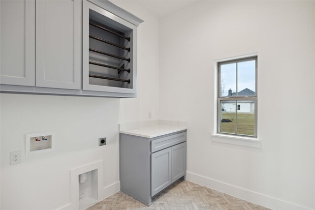 clothes washing area with electric dryer hookup, cabinets, and washer hookup