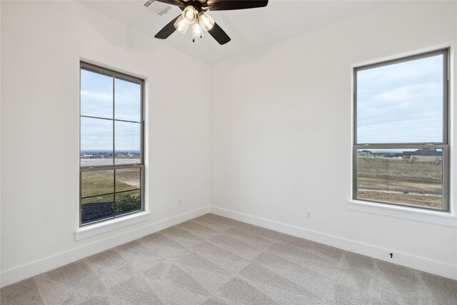 carpeted spare room featuring ceiling fan