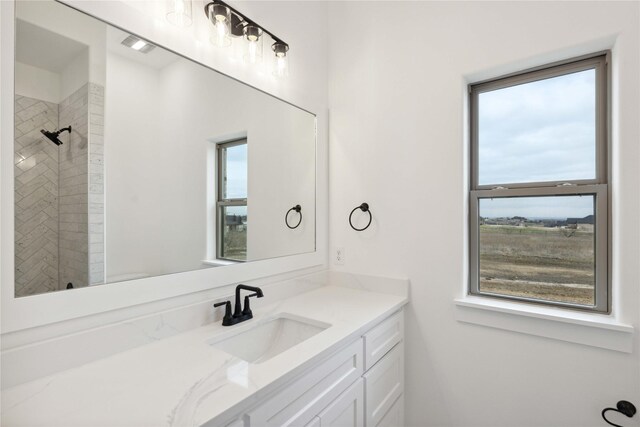 bathroom with vanity and a tile shower