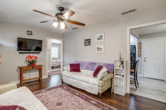 living room featuring dark hardwood / wood-style flooring and ceiling fan