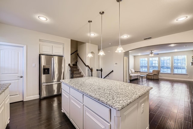 kitchen with hanging light fixtures, a center island, white cabinets, and stainless steel refrigerator with ice dispenser