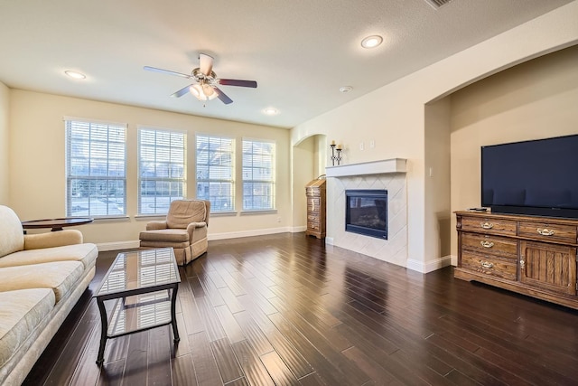 living room with a fireplace, dark hardwood / wood-style floors, and ceiling fan