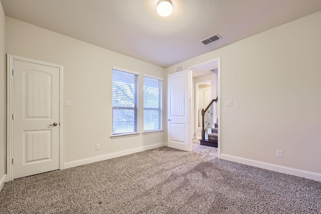 unfurnished bedroom featuring carpet flooring and a textured ceiling