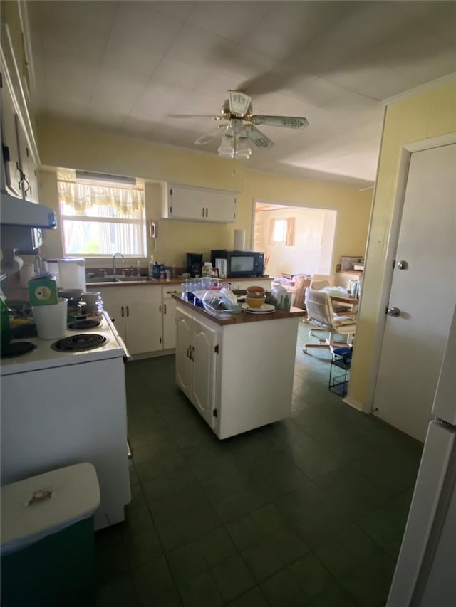 kitchen featuring a center island, white cabinetry, sink, electric stove, and range hood