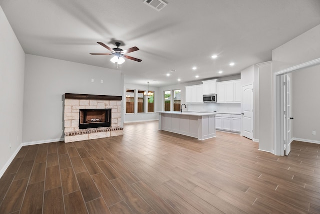 kitchen featuring recessed lighting, stainless steel microwave, visible vents, a ceiling fan, and open floor plan