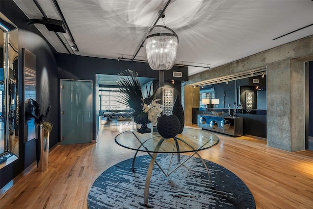 dining area with basketball hoop, a notable chandelier, and hardwood / wood-style flooring