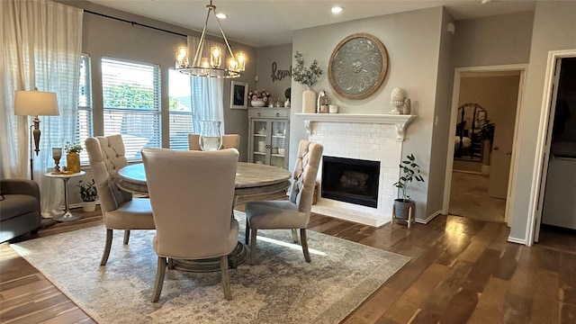 dining room featuring a fireplace, dark hardwood / wood-style flooring, and a chandelier