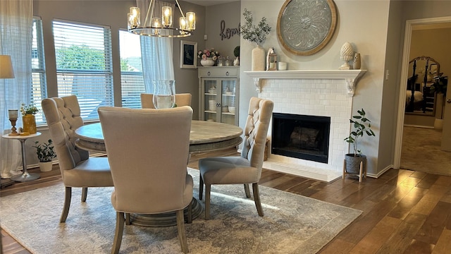 dining space featuring dark hardwood / wood-style floors, a fireplace, and a notable chandelier