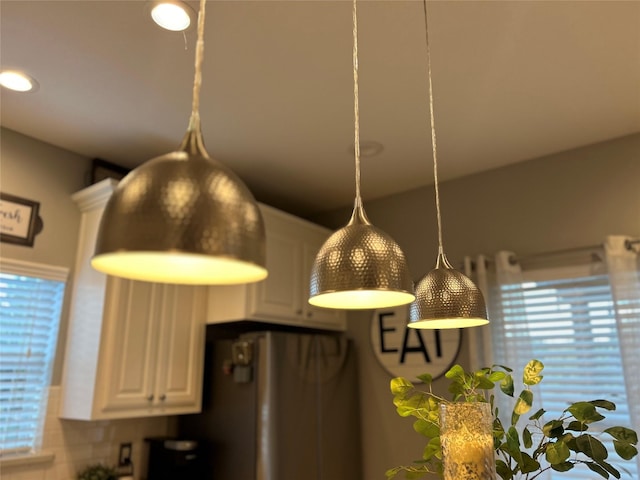 details featuring hanging light fixtures and white cabinets