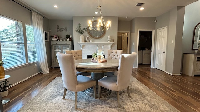 dining space with dark hardwood / wood-style floors and a chandelier