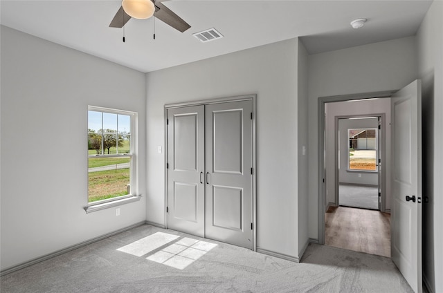 316 Clubview Dr, Bowie, TX 76230 - unfurnished bedroom with light colored carpet, visible vents, baseboards, and a ceiling fan