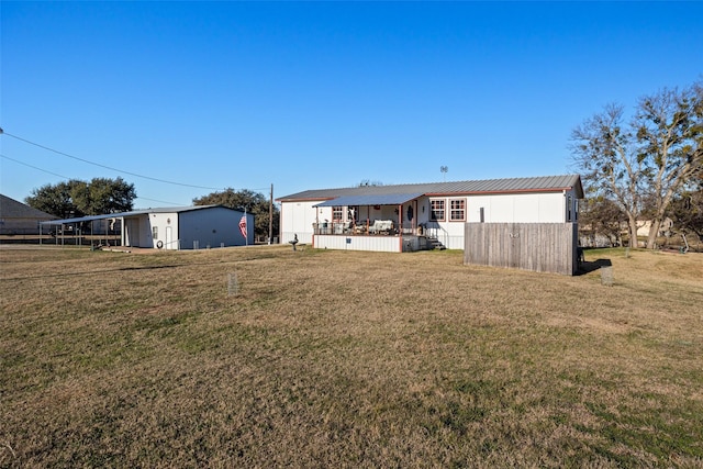 rear view of property featuring covered porch and a yard