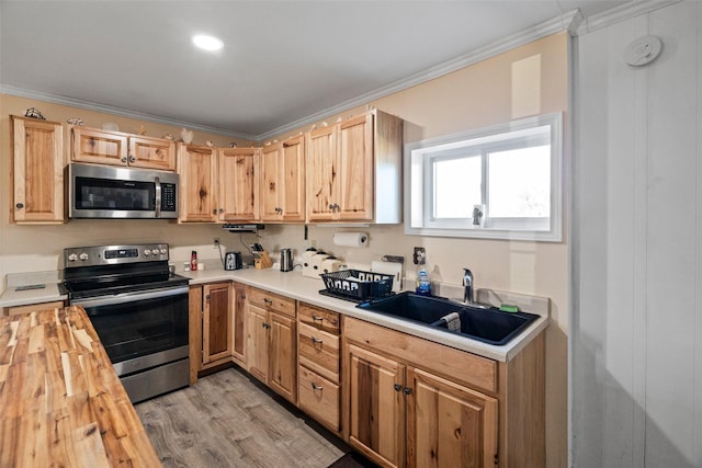 kitchen featuring appliances with stainless steel finishes, sink, wooden counters, light hardwood / wood-style floors, and crown molding