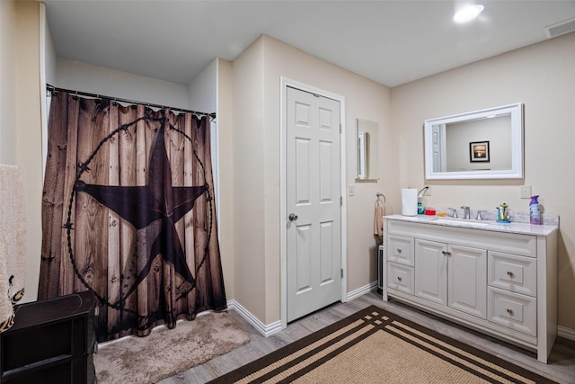 bathroom with hardwood / wood-style flooring and vanity