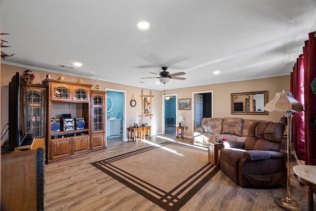 living room featuring light wood-style flooring, a ceiling fan, crown molding, and recessed lighting