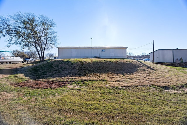 view of property exterior featuring an outdoor structure and a lawn