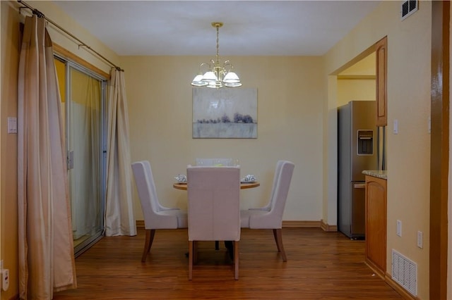 dining room featuring light wood-type flooring and an inviting chandelier