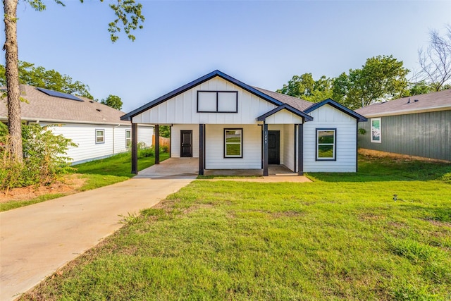 modern farmhouse with a front yard, a porch, and a carport