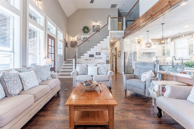 living room with dark wood-type flooring and high vaulted ceiling