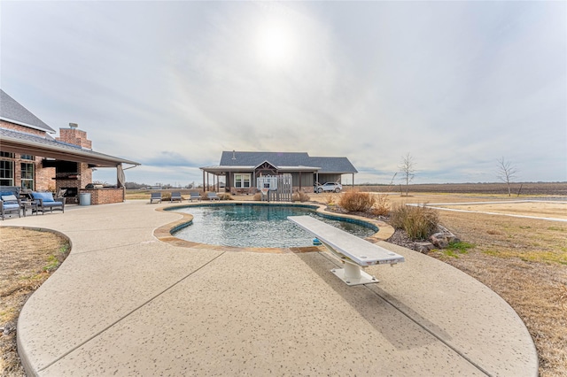 view of swimming pool featuring a patio area, a diving board, and area for grilling