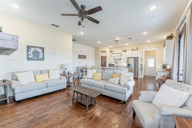 living room featuring dark hardwood / wood-style floors and ceiling fan