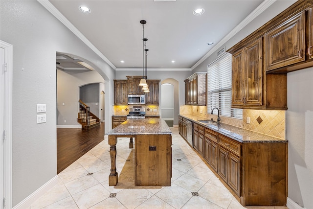 kitchen featuring dark stone counters, a center island, light tile patterned floors, and stainless steel appliances