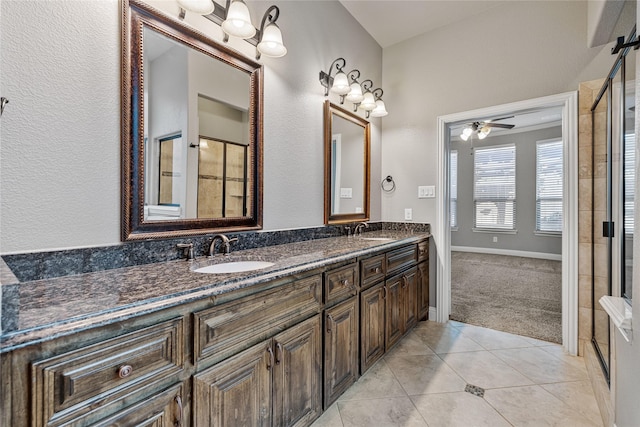 bathroom with tile patterned floors, ceiling fan, a shower with shower door, and vanity