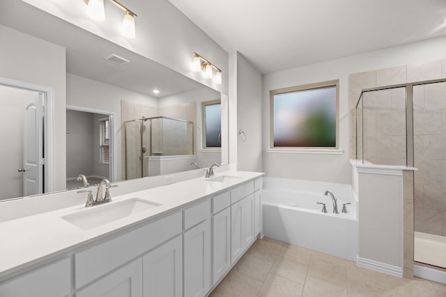 bathroom featuring double vanity, a bath, a sink, visible vents, and a stall shower