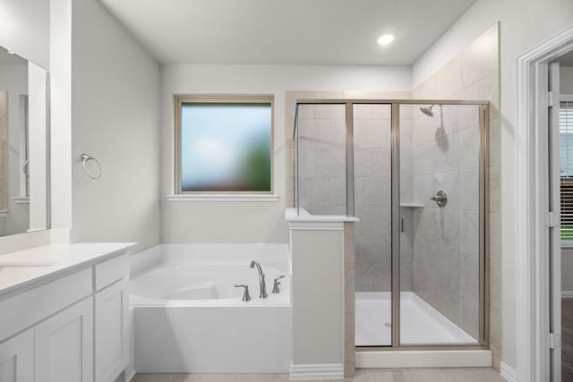 bathroom with a garden tub, a stall shower, vanity, and a healthy amount of sunlight