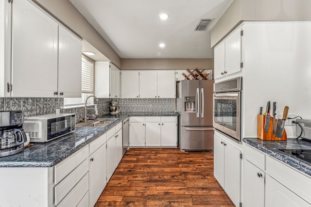 kitchen featuring tasteful backsplash, sink, white cabinets, and stainless steel appliances