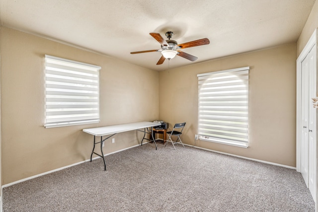 unfurnished office with ceiling fan, plenty of natural light, and carpet