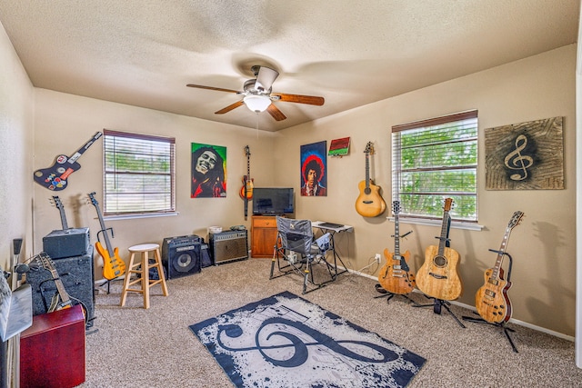 recreation room featuring ceiling fan, carpet floors, and a textured ceiling