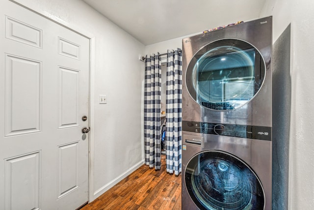 clothes washing area with stacked washer and dryer and dark hardwood / wood-style floors