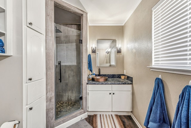 bathroom featuring crown molding, vanity, wood-type flooring, and an enclosed shower