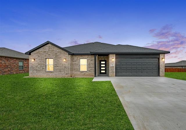 view of front of property featuring a garage and a lawn