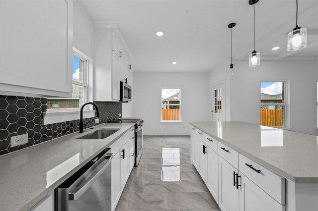 kitchen featuring light stone countertops, white cabinets, appliances with stainless steel finishes, decorative backsplash, and sink