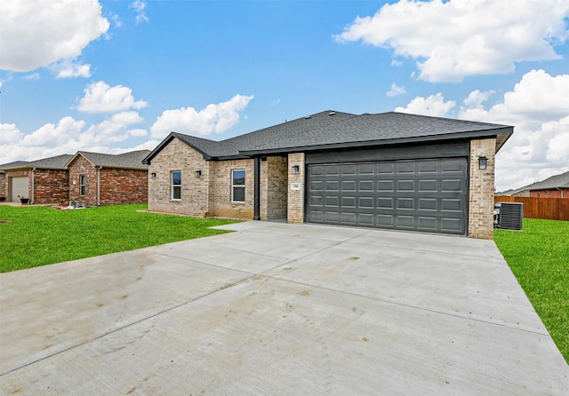 view of front of property featuring a front yard, central AC unit, and a garage