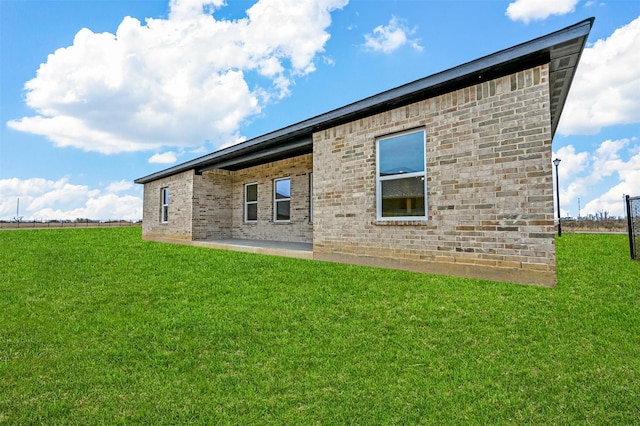 back of house with a patio area and a lawn