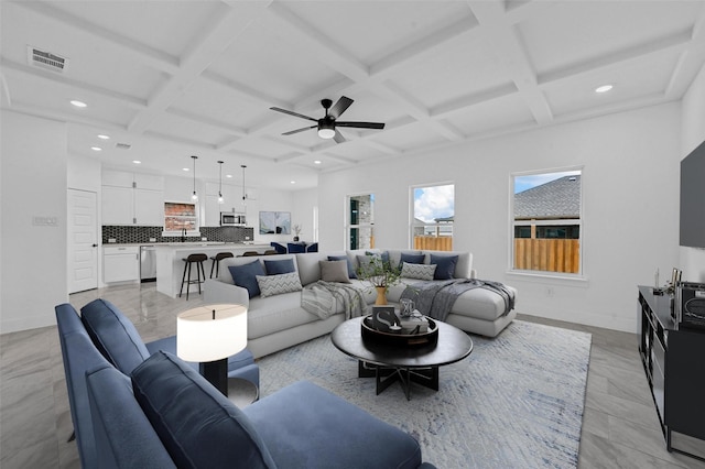 living room with ceiling fan, beamed ceiling, and coffered ceiling