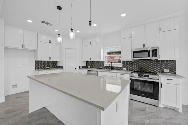 kitchen featuring a center island, white cabinets, sink, pendant lighting, and stainless steel appliances