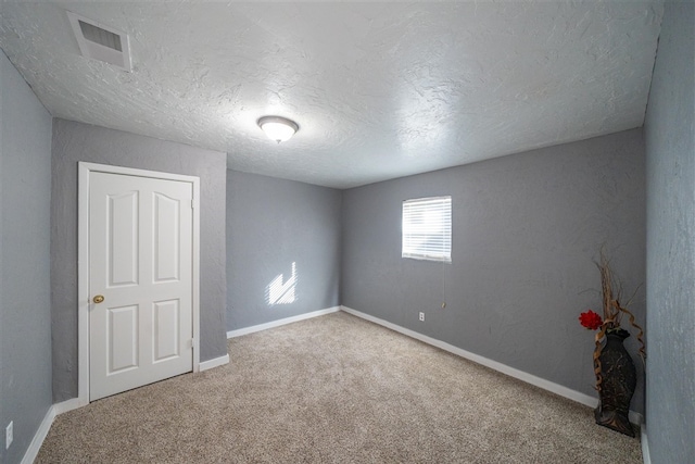 spare room with carpet and a textured ceiling