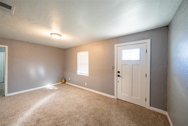 view of carpeted foyer entrance