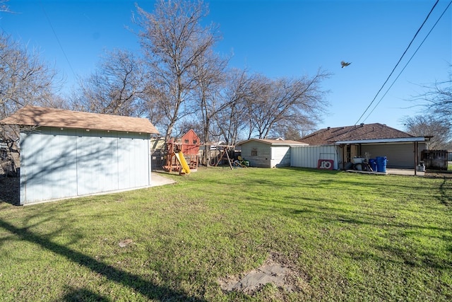 view of yard featuring a playground and a storage unit