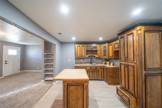 kitchen featuring a center island, butcher block countertops, light hardwood / wood-style floors, and sink