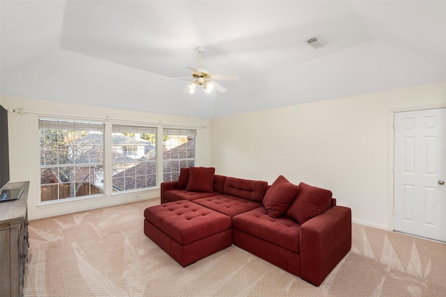 carpeted living room with ceiling fan and a tray ceiling