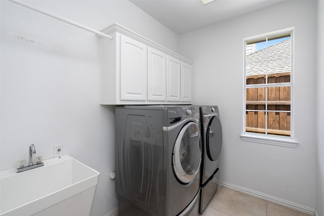 laundry room with washer and clothes dryer, sink, light tile patterned flooring, and cabinets