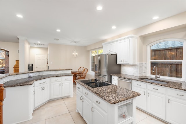 kitchen featuring sink, a center island, decorative backsplash, white cabinets, and appliances with stainless steel finishes