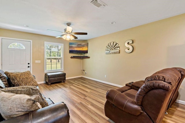 living room with light hardwood / wood-style flooring and ceiling fan